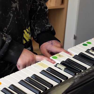 Hände einer Schülerin spielen Keyboard